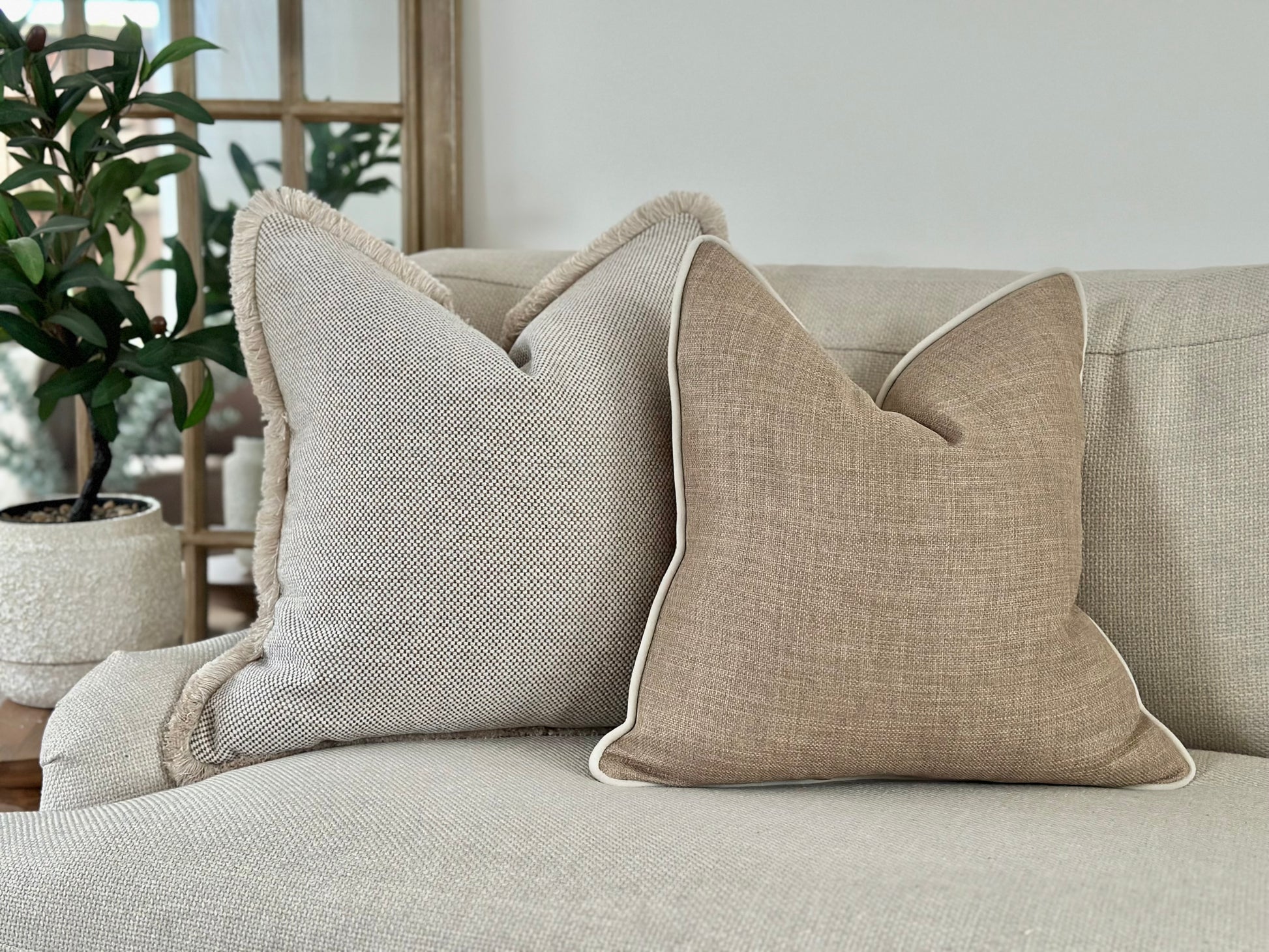 A collectionLuxury cushions in natural earthy tones like ivory, off white beige and browns that are cosy and inviting.