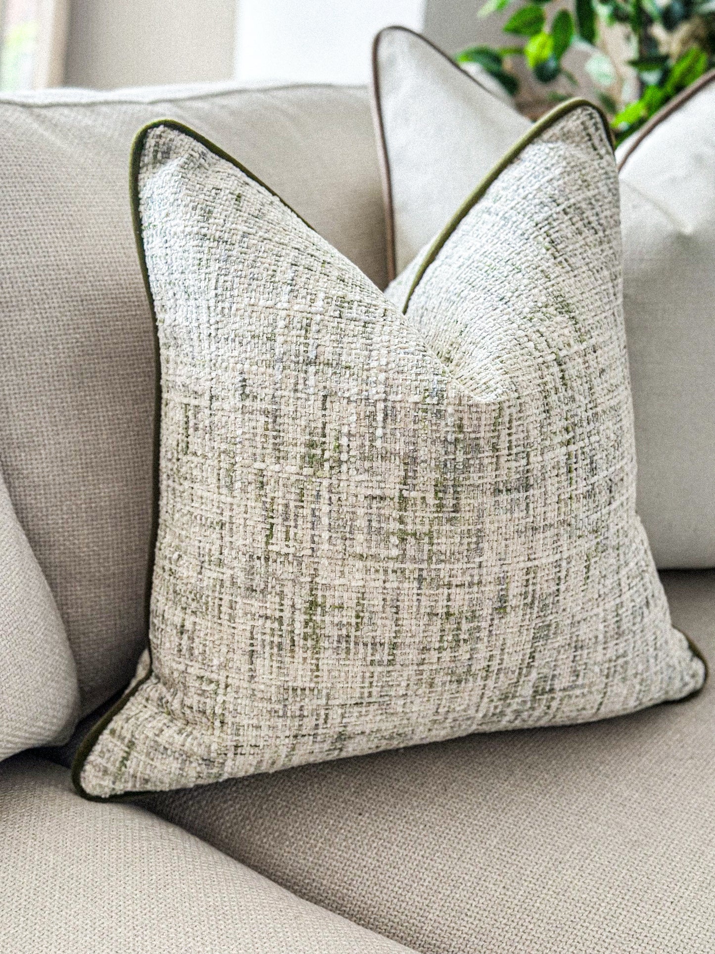Woven neutral and green pillow cover designed for timeless, cosy living spaces.