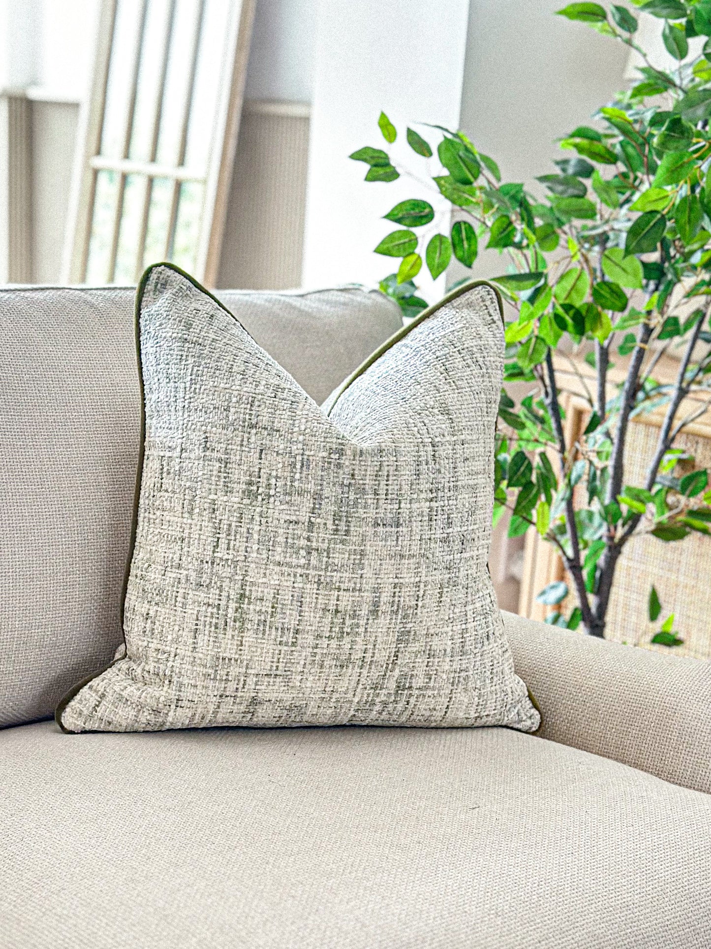 Cosy textured weave pillow with hints of green prefect for modern organic earthy decor.