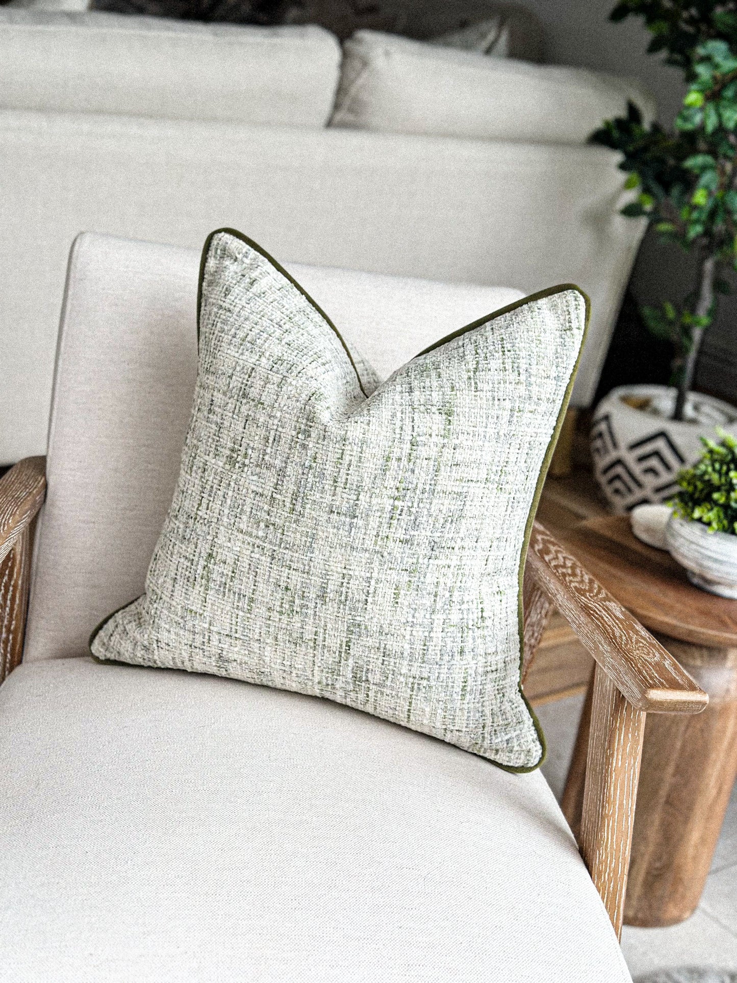 Fern green and stone woven cushion — perfect for earthy, neutral home décor.