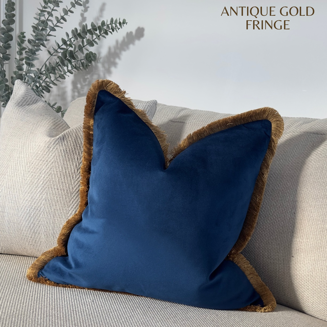 Blue velvet throw pillow with customisable antique gold fringe.