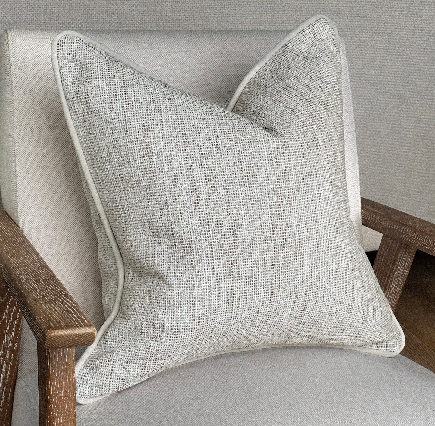 Neutral textured cushion cover with piping.