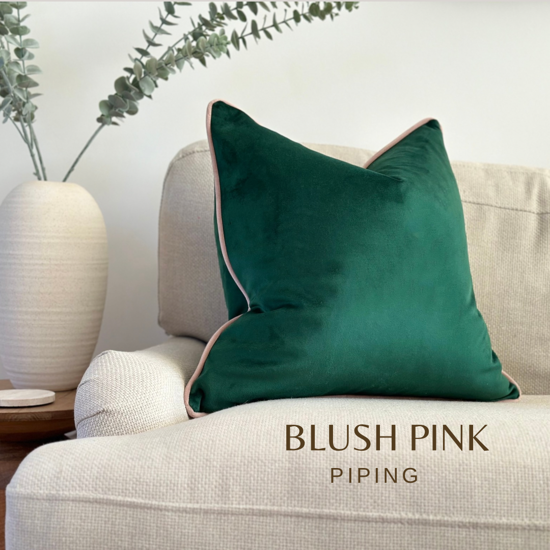 Forest green velvet cushion with a blush pink piping trim.