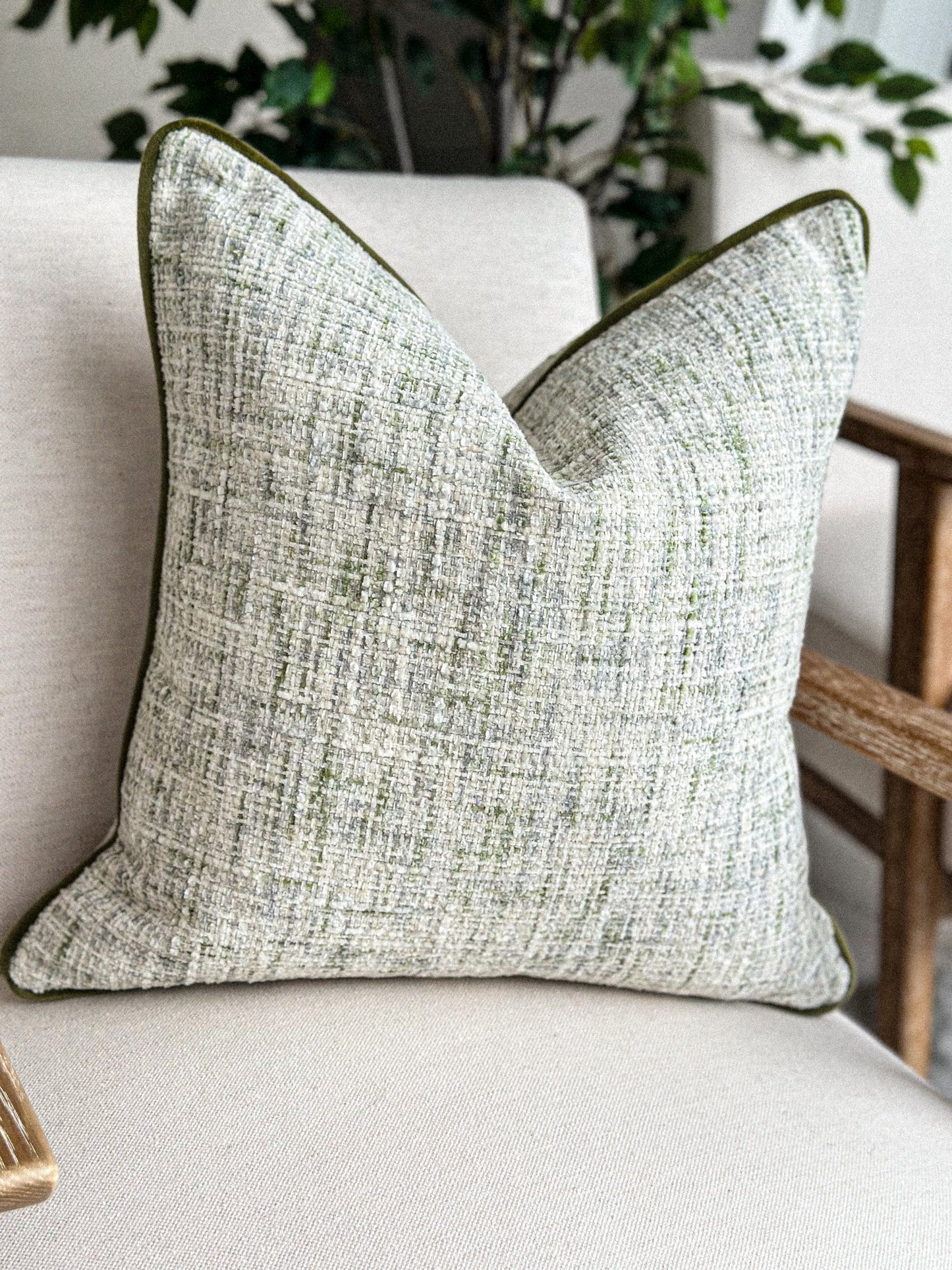 Textured sage green and cream woven cushion, perfect for neutral, earthy interiors.