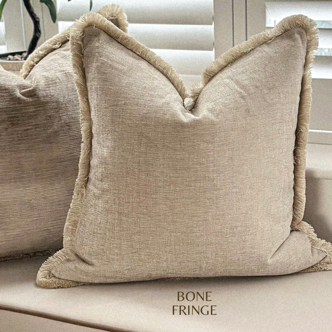 Neutral scatter cushion with fringing.