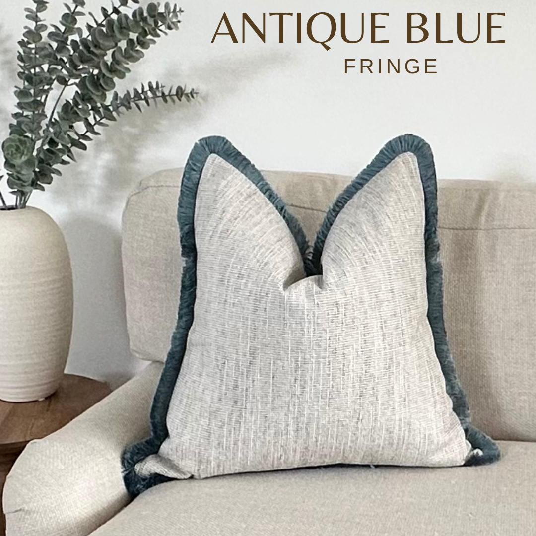 A photo of a Neutral cushions cover with blue fringe custom made by the cosy cushion shop. The cushion is perfect for costal home interiors.