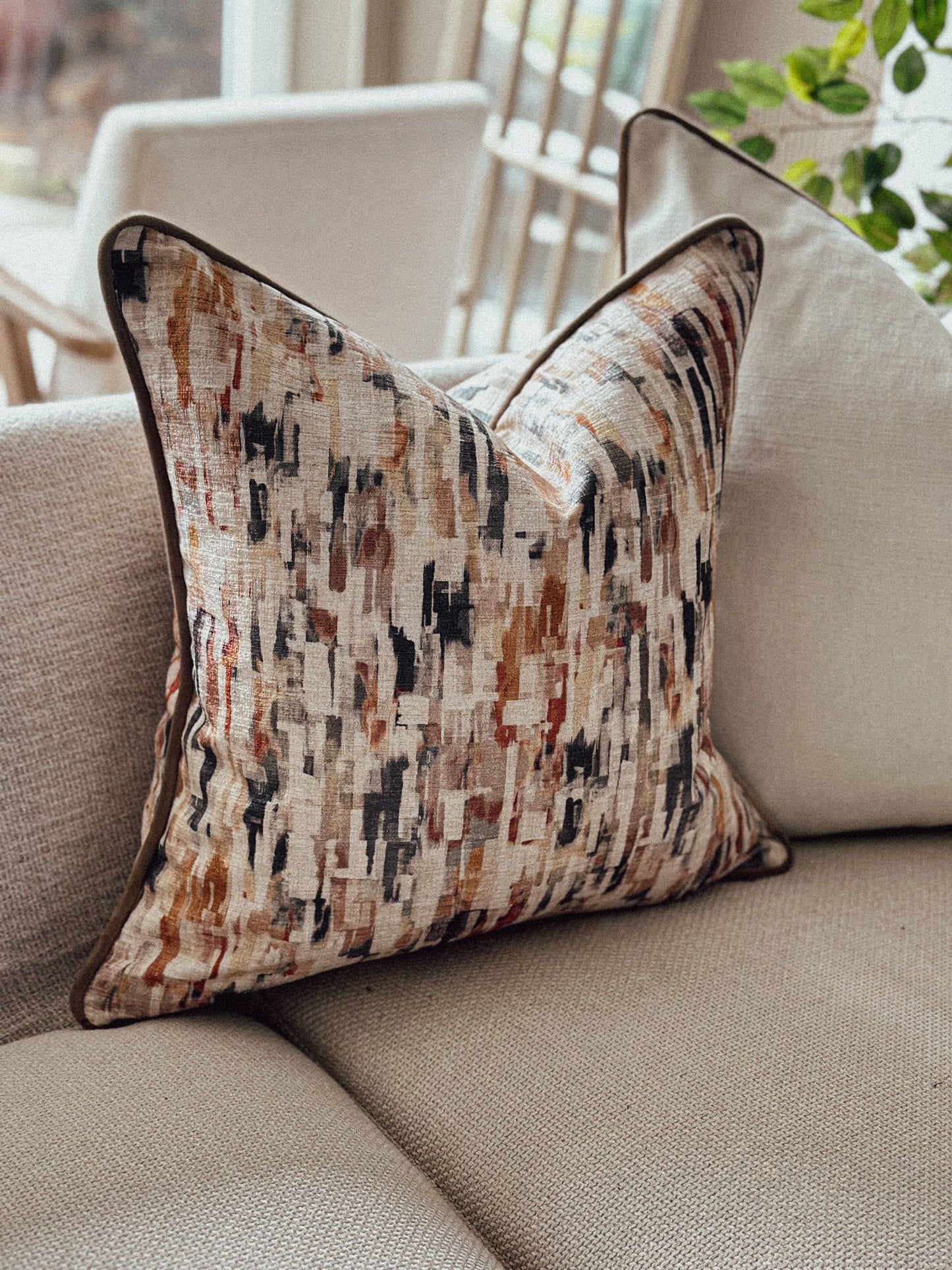 Warm terracotta and rust patterned cushion with painterly design — perfect for earthy autumn déco