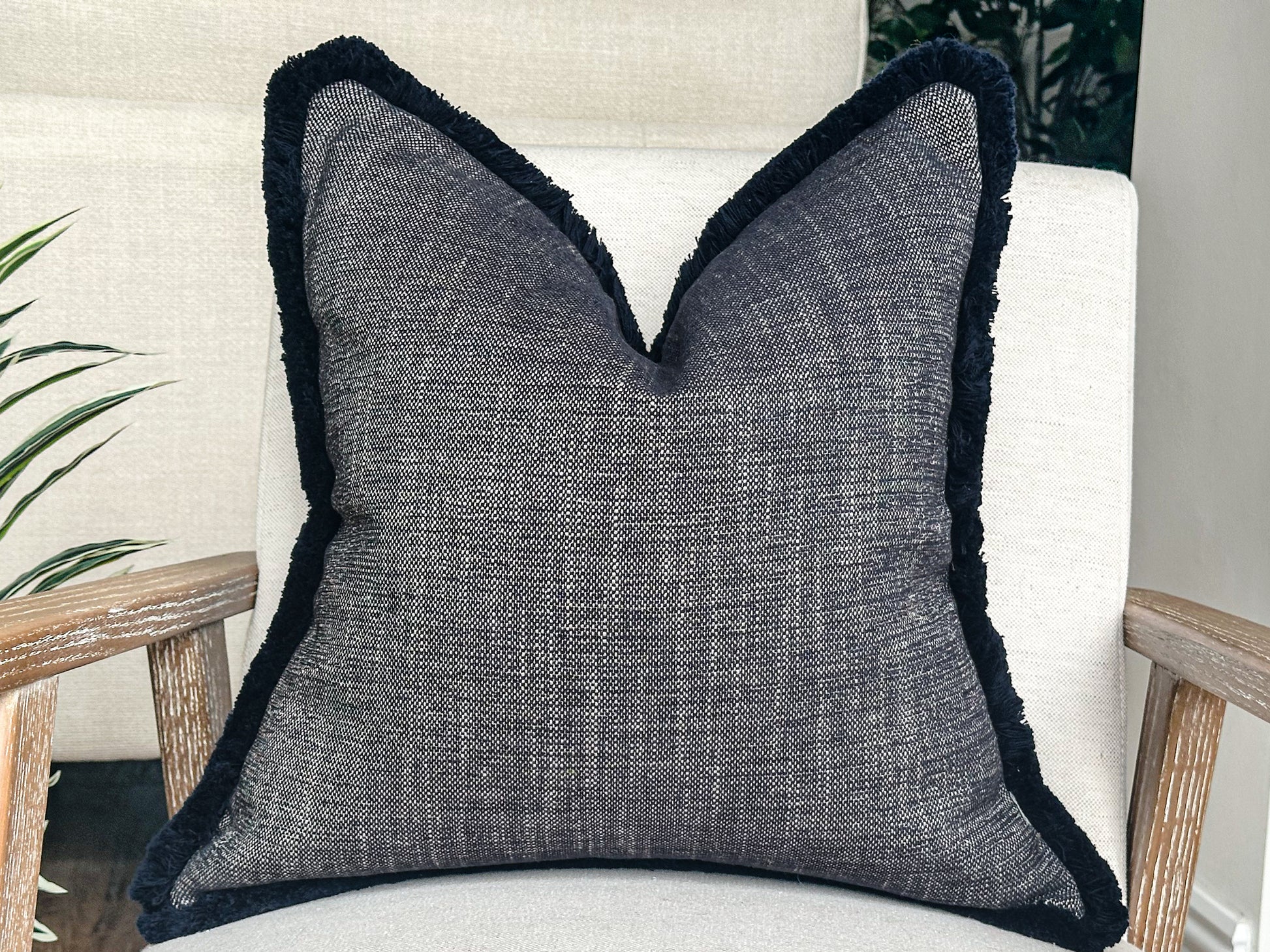 Blue textured pillow with fringe trim.
