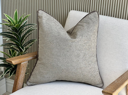Beige pillow with trim.