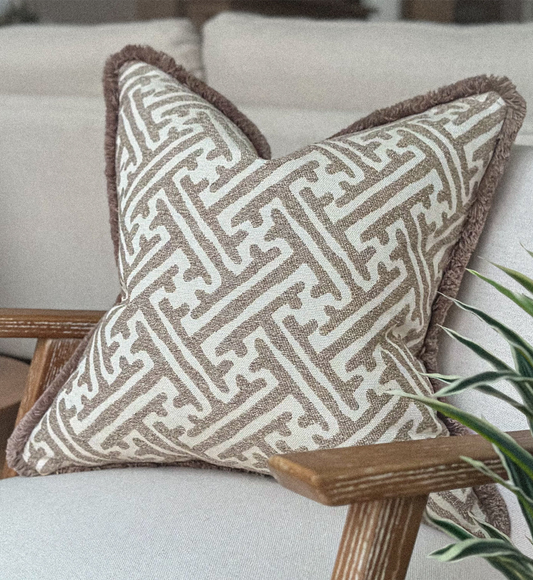 Luxury Stone and taupe geometric cushion with beige fringe styled for neutral home decor.