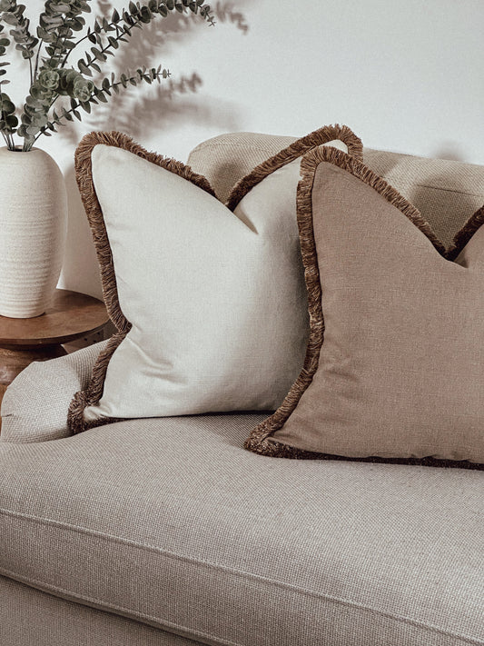 Light Cream cushion with beige fringe trim.