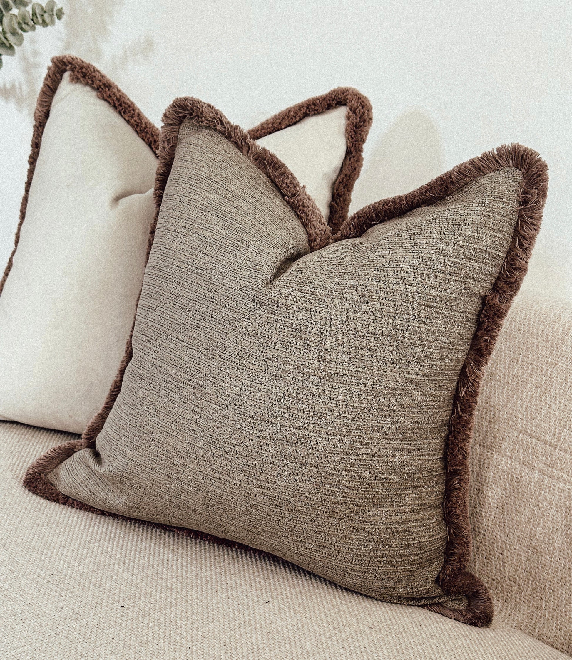 Neutral scatter cushions with fluffy edge.