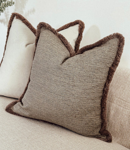 Neutral scatter cushions with fluffy edge.