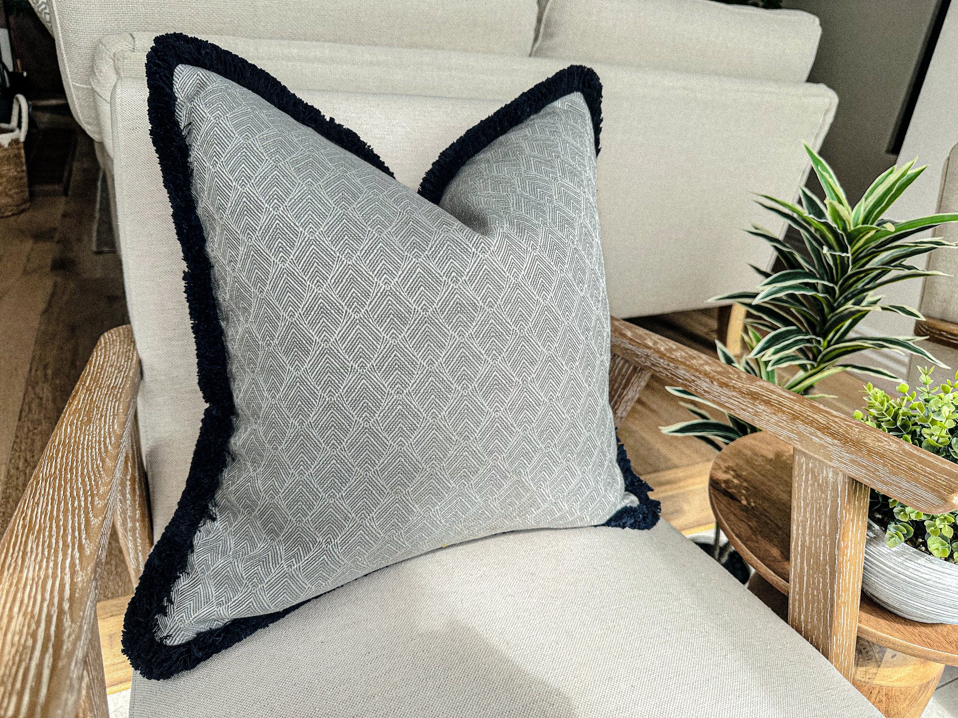 Silver grey Geometric cushion cover with fringe trim.