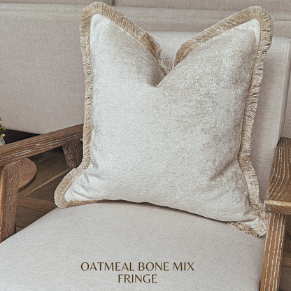 Textured white pillow with fringed edge.