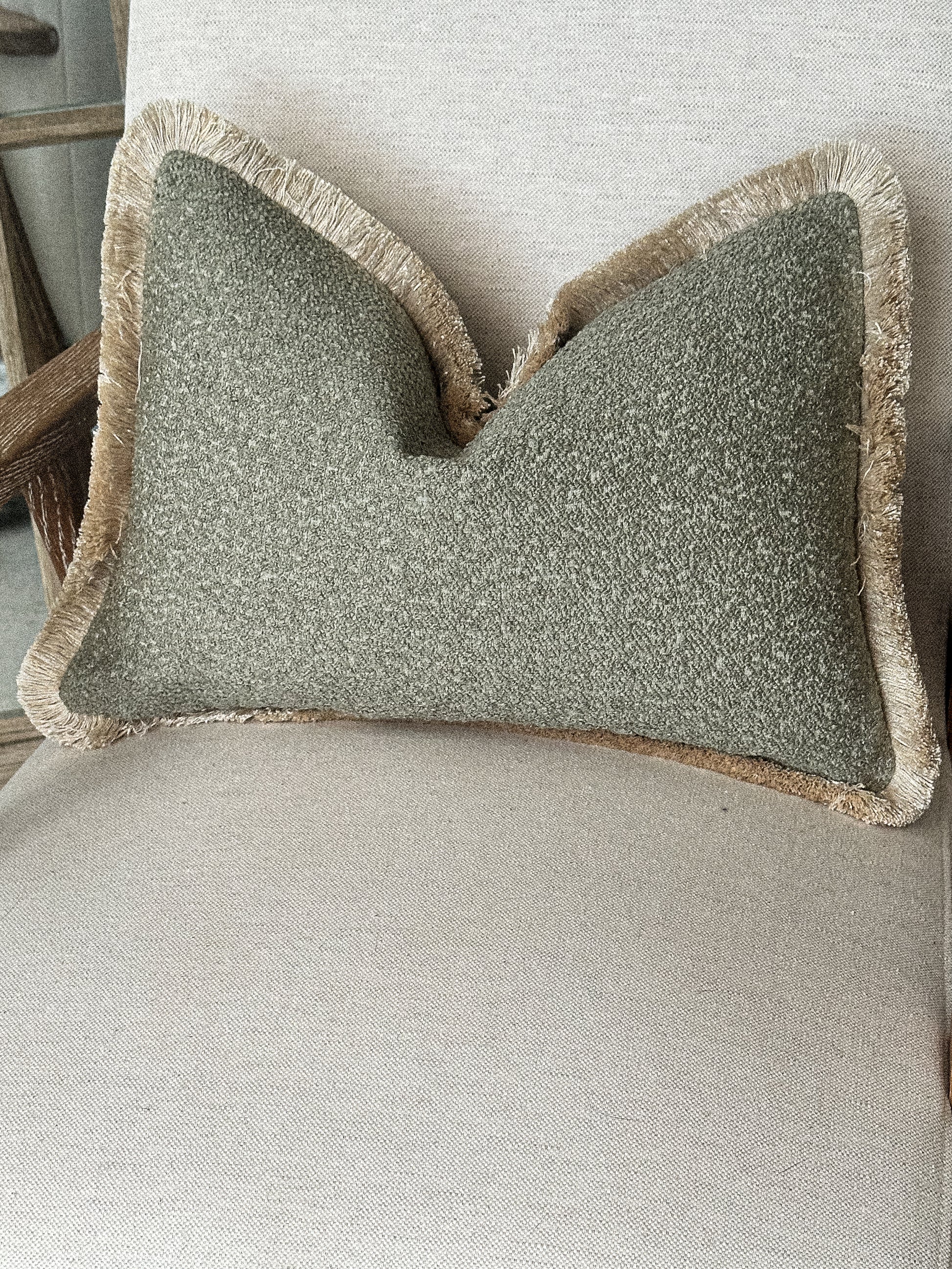 Sage green boucle fringed cushion.