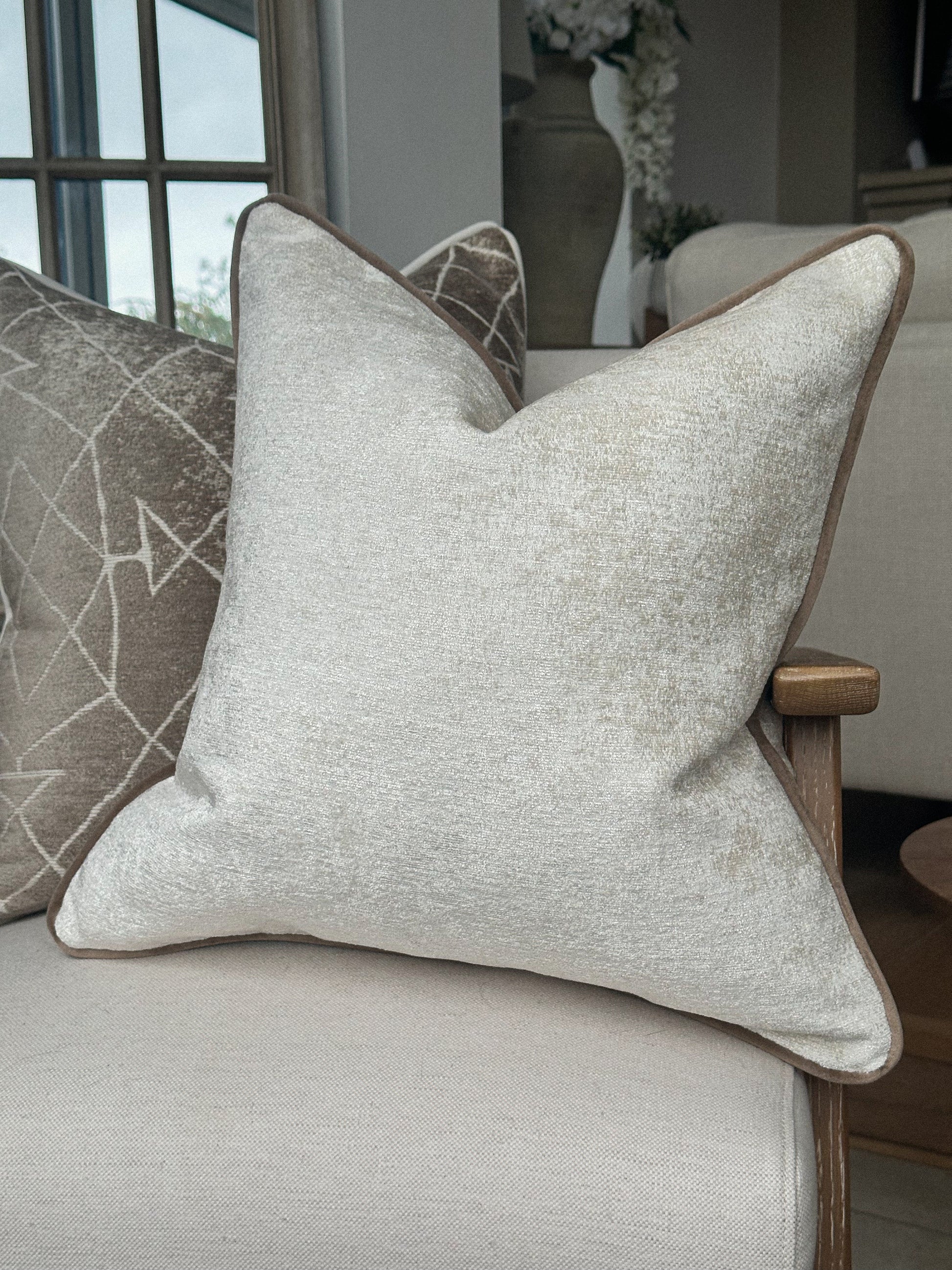 Off white neutral scatter cushion with beige edge.