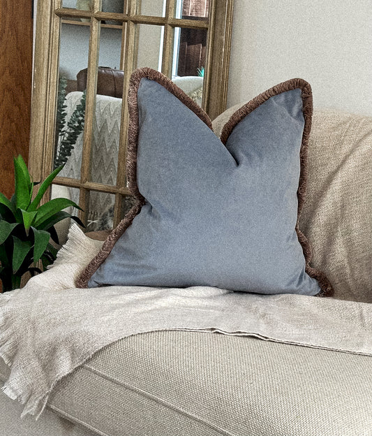 Powder muted blue velvet cushion with customisable beige fringe trim.