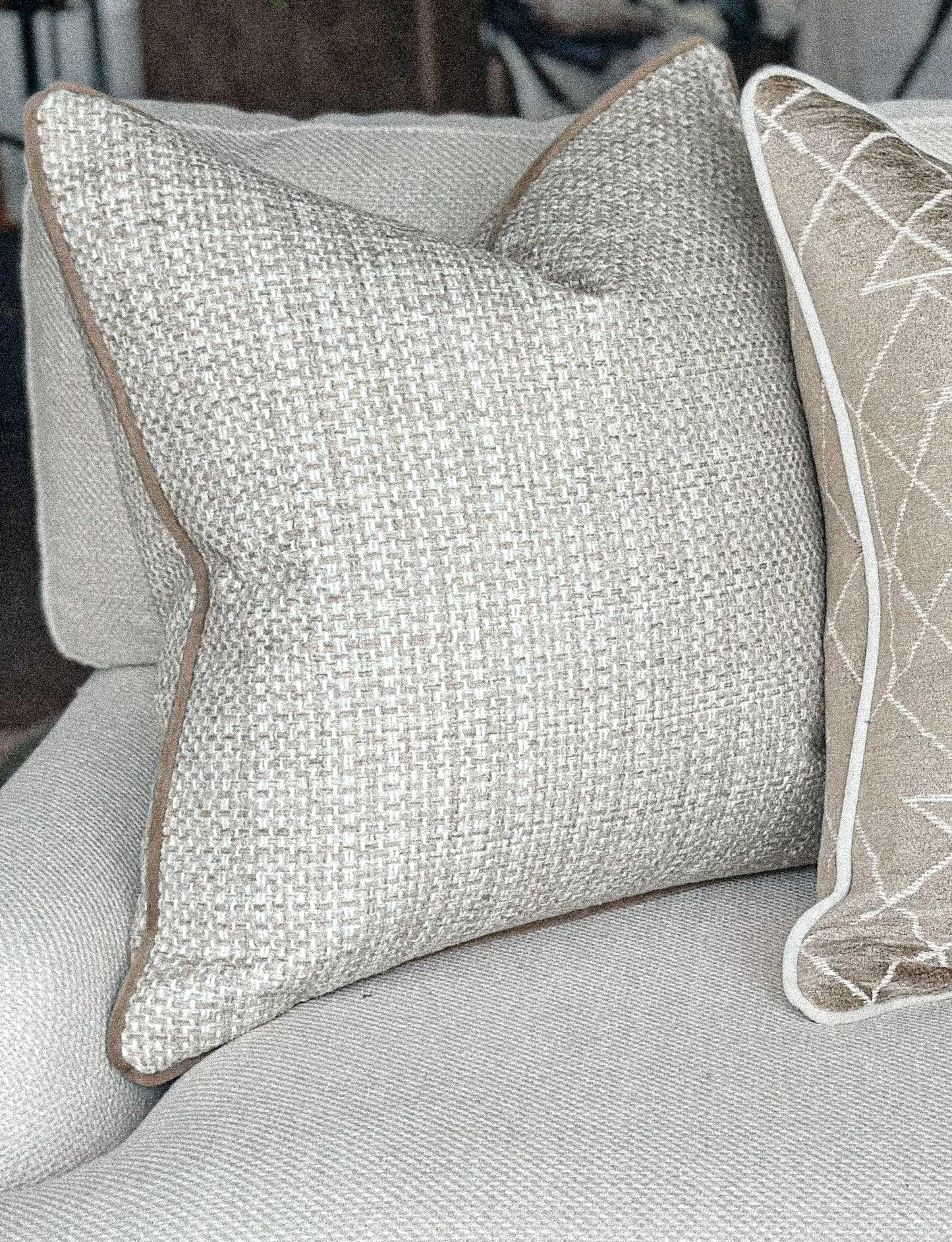 Neutral chunky weave cushion with taupe edge.