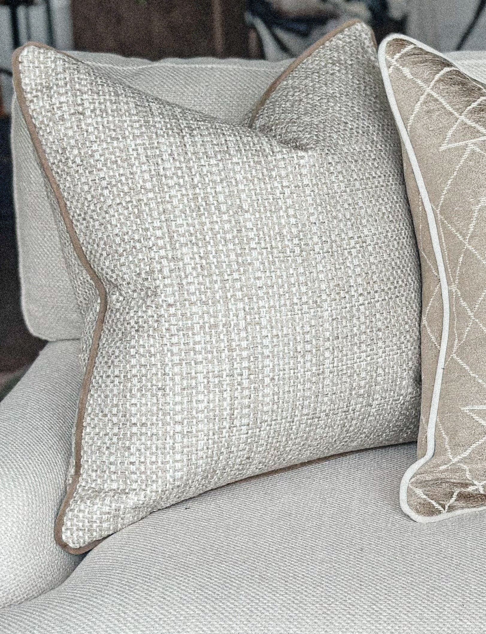 Neutral chunky weave cushion with taupe edge.