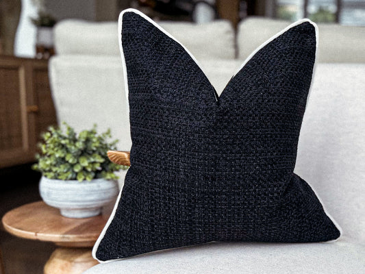 Textured black weave cushion with customisable off white piping.