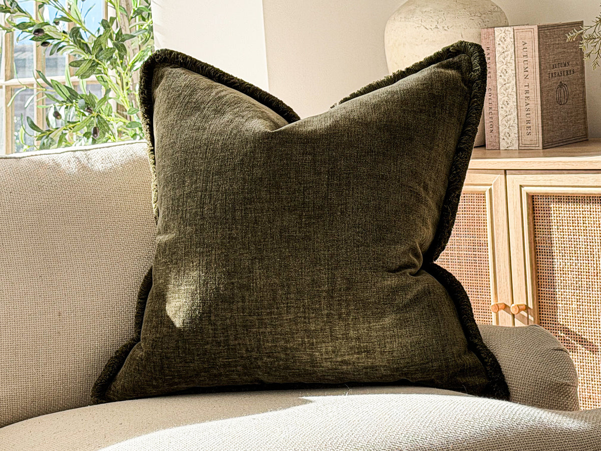 A Luxury earthy green textured scatter cushion with fringe trim.