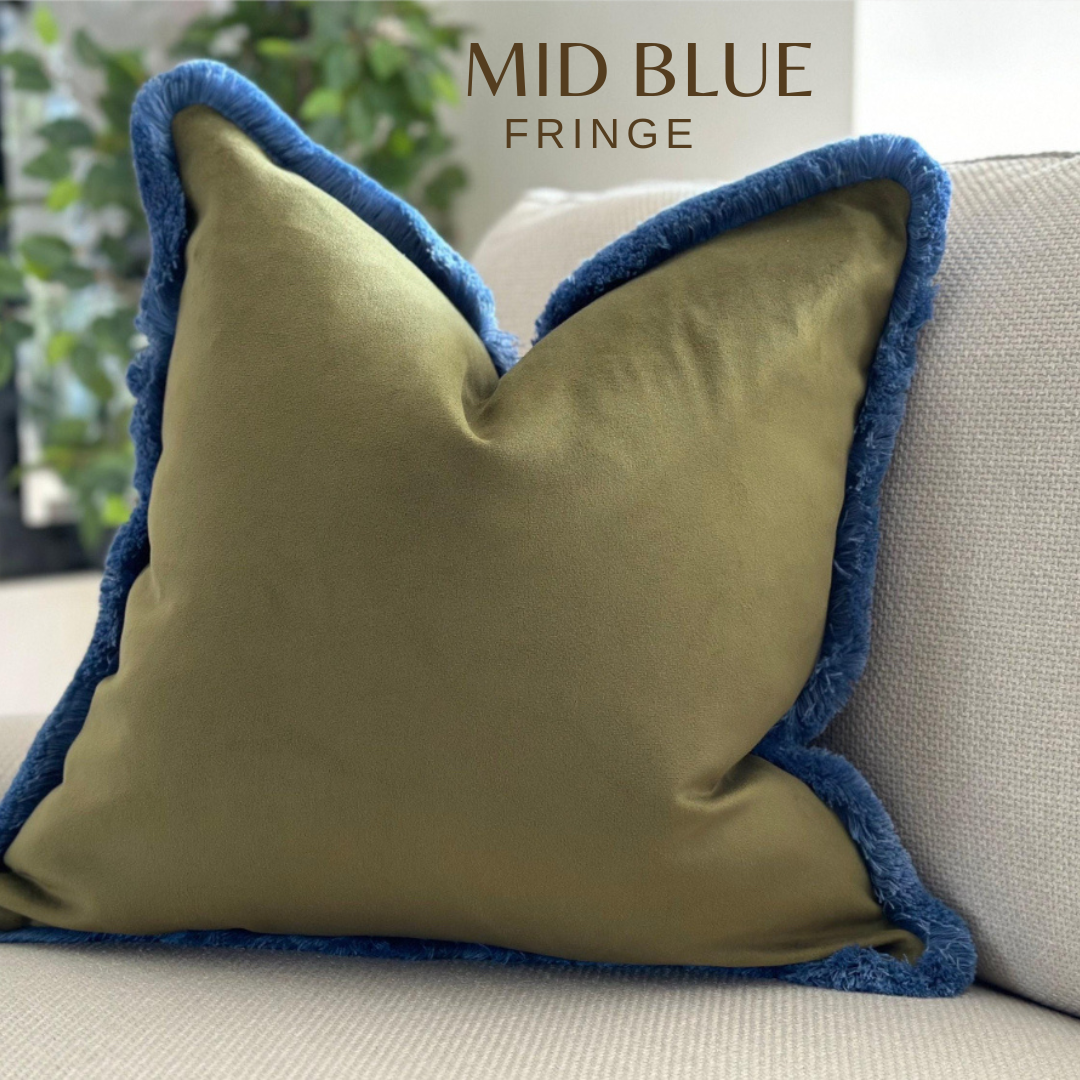 Moss green velvet cushion with blue fringe.