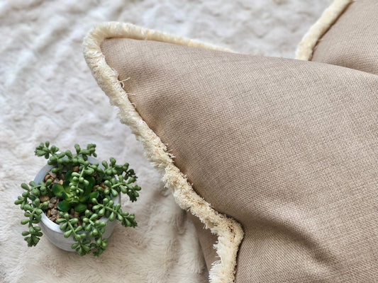 Beige rustic fringed pillow cover.