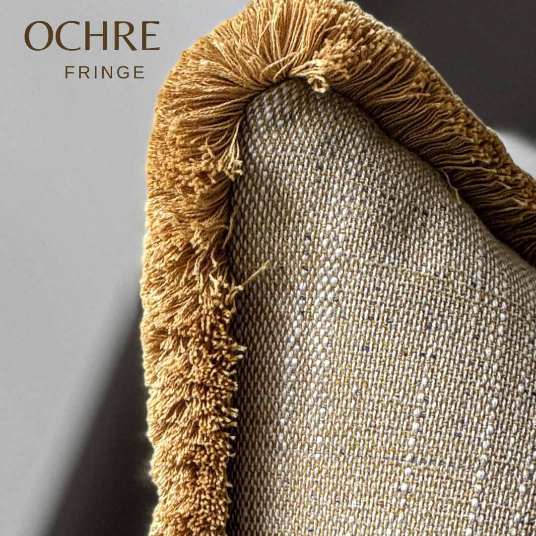 A close-up of a woven textile with a prominent ochre fringe trim, showing the texture of both the woven fabric and the fringed edge. The text 'OCHRE FRINGE' is visible in the top left corner.