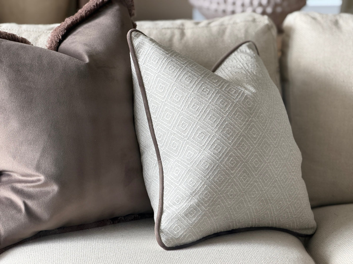 Natural ivory geometric cushion with brown piping