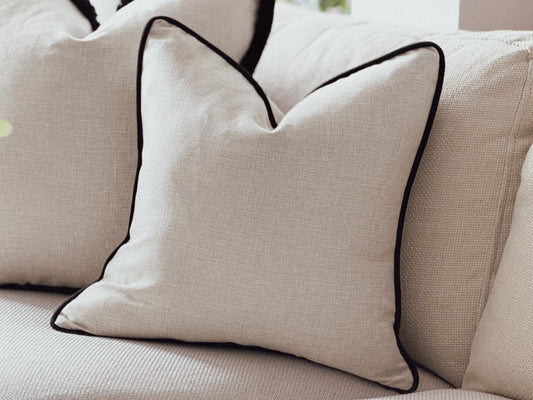 Natural cushions with a black piping trim.