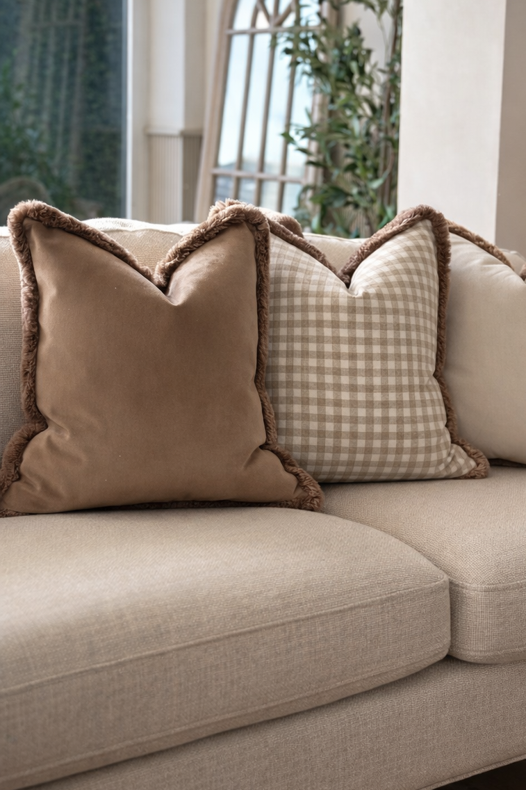 Neutral taupe check cushion with plush fringed trim — perfect for modern organic living spaces.