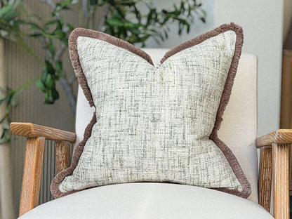 A beautiful green and ivory cream textured weave cushion with fringing.