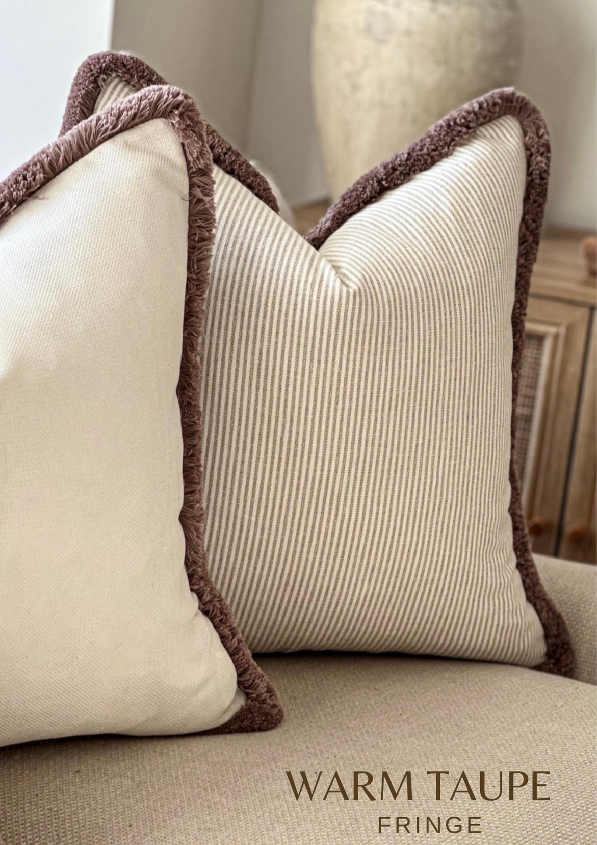 Beige ticking stripped cushion with fringe trim.
