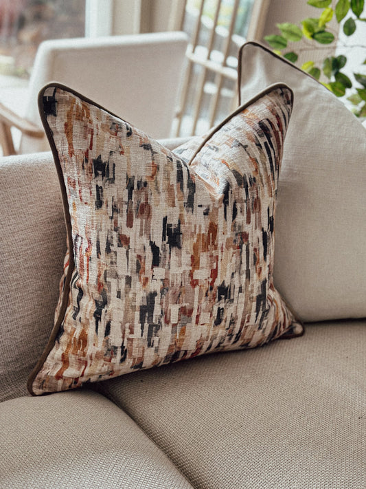 Warm terracotta and rust patterned cushion with painterly design — perfect for earthy autumn déco